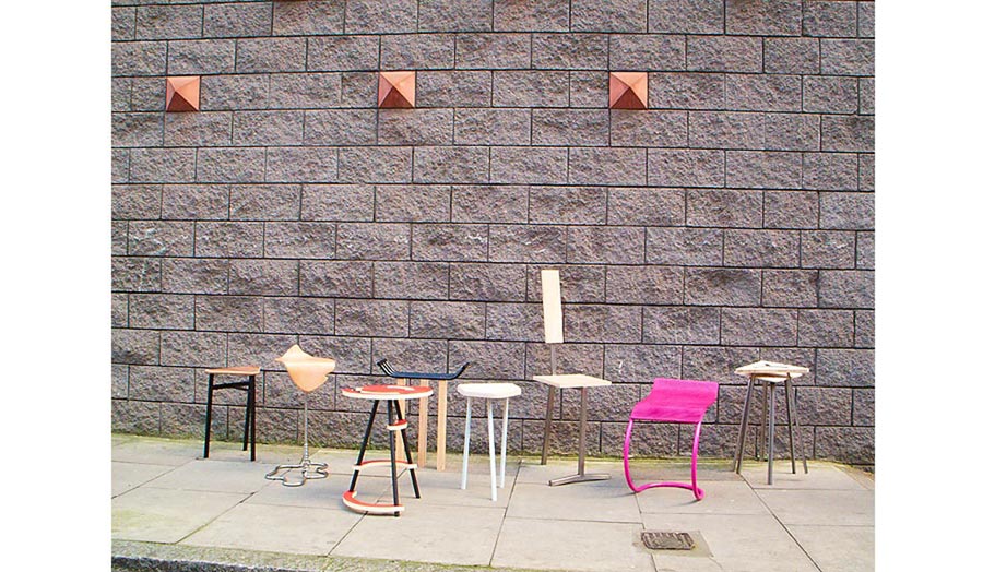 Display of chairs against a street wall