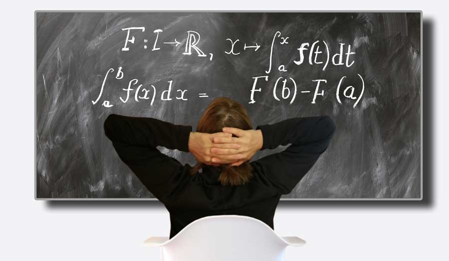 a person sitting in a white chair facing a blackboard with mathematical calculus on it 