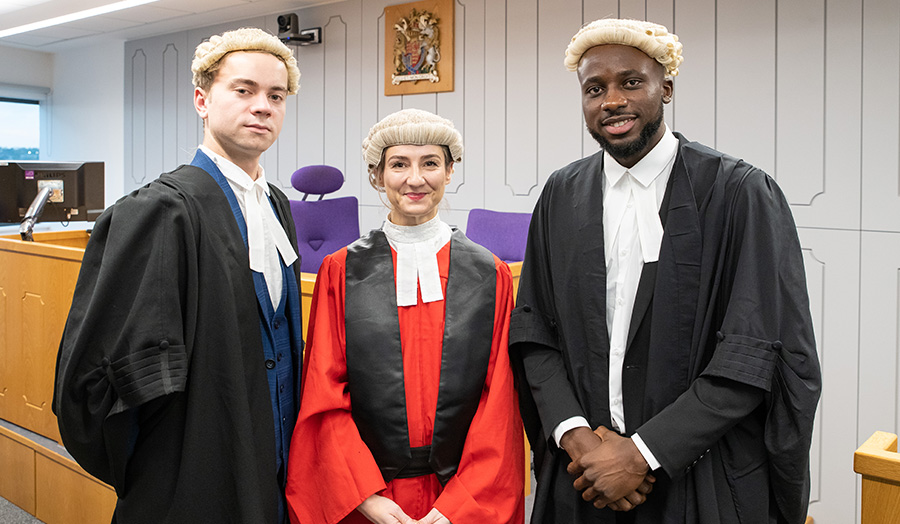 Three people wearing formal court dress including gowns and wigs