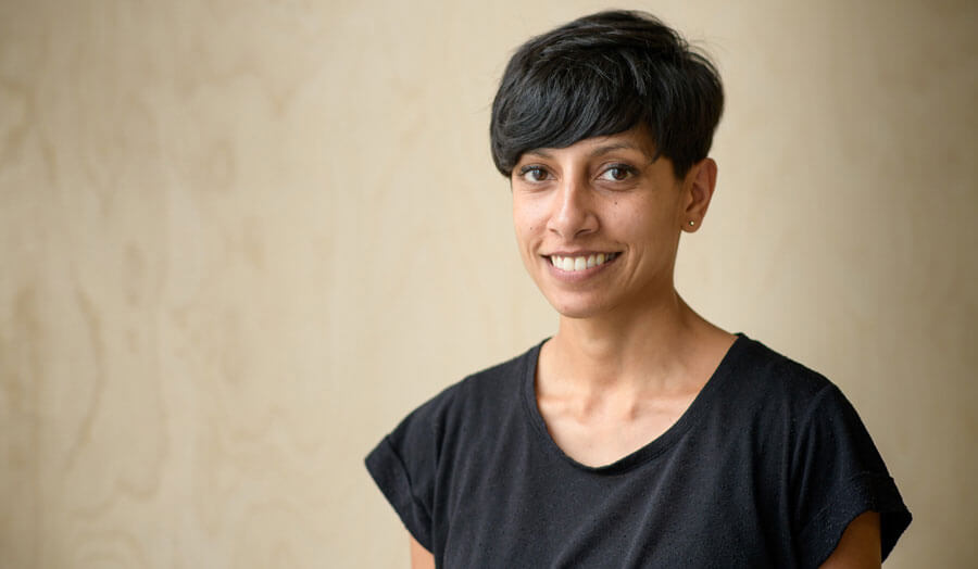 Alpa Depani, a female lecturer with short hair in a black T-shirt, smiles to camera.