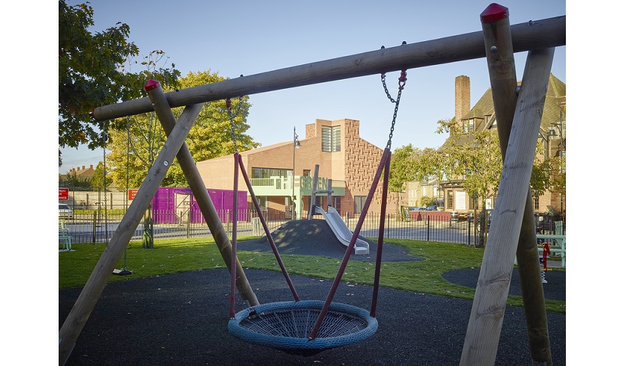 Playground with swing, and buildings in background