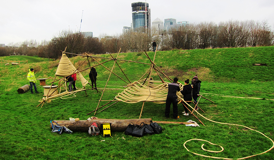 Image of students assembling small huts in a large field