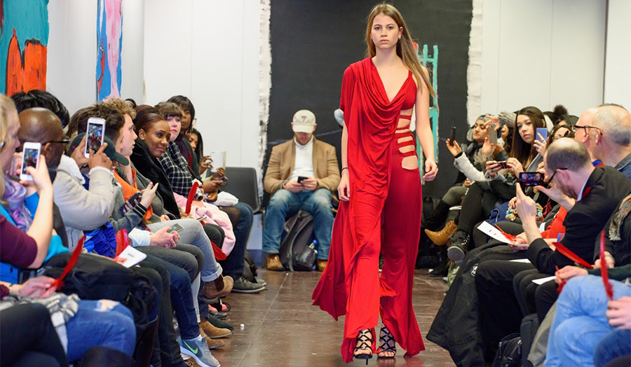 woman in red dress sashays down catwalk