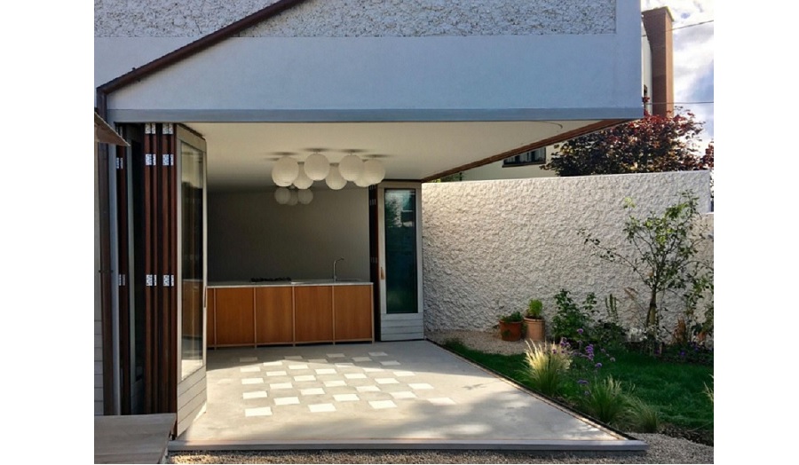 Rear of a house with garden doors opened so indoor and outdoor space are indistinguishable