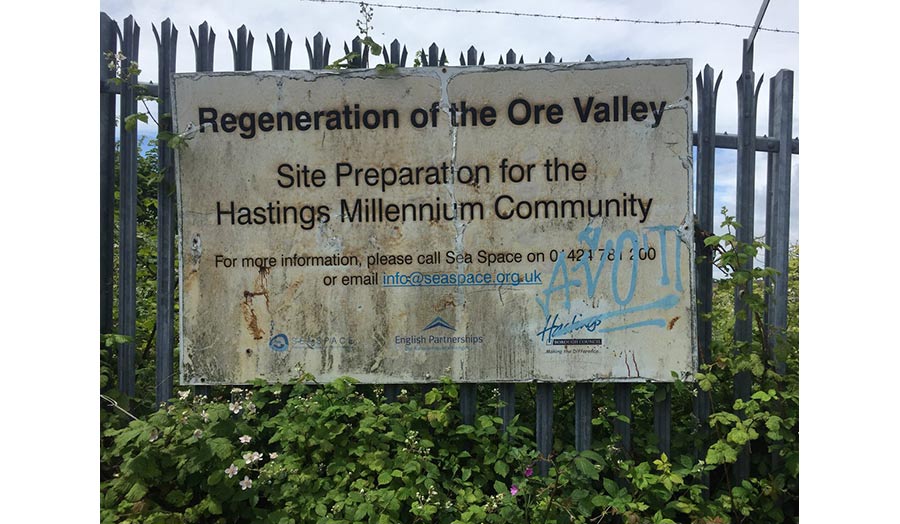 A metal fence with a sign that reads, Regeneration of the Ore Valley