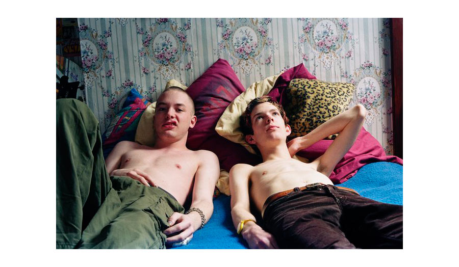 Two young boys lying in trendy pants and shirtless