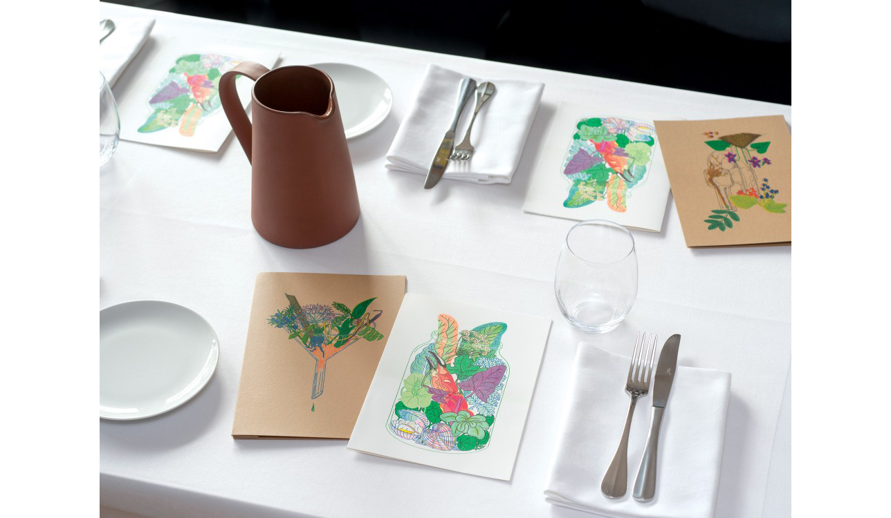 table with crockery and cutlery, and hand drawn menus