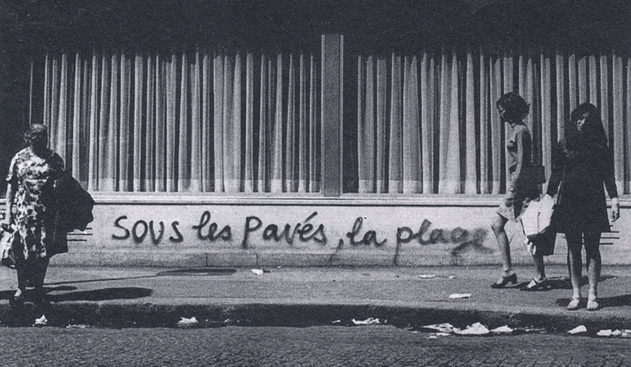Paris street with French graffiti slogan "Sous les paves, la plage!", as used by protestors