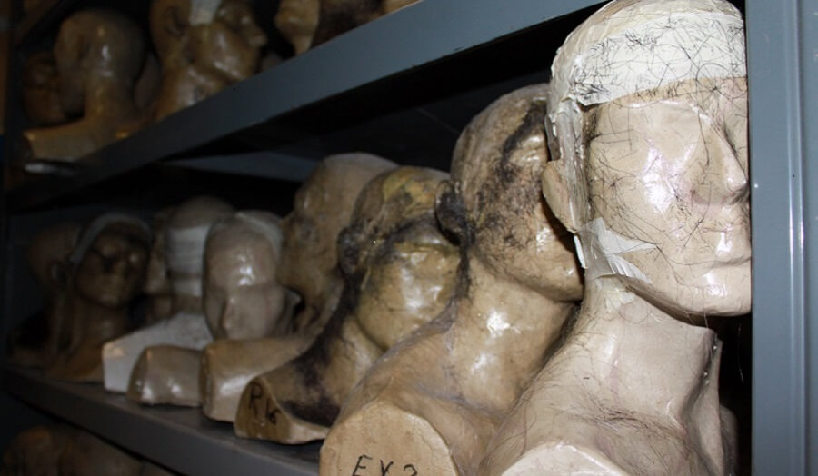 Many plaster cast heads on shelving within the studio 