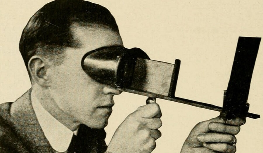 Victorian sepia photo of man's head looking through early 3D viewing device