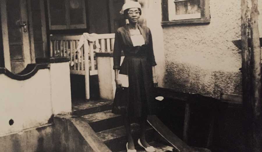  Unknown lady, on steps outside a home in Kingston Jamaica