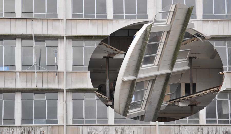 10m diameter ovoid section in facade of disused building cut free allowing it to rotate