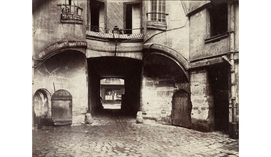 A passage into a Parisian courtyard is framed by sculptural facades