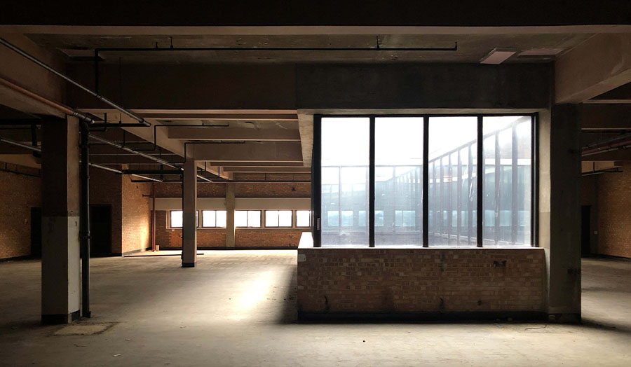 An interior picture of a stripped-out warehouse building.