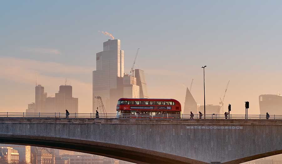 London double-decker bus coming over Waterloo Bridge at sunset