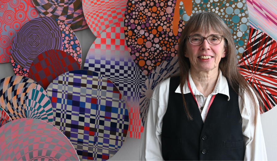 Sandra Sinfield pictured with colourful abstract artworks behind her