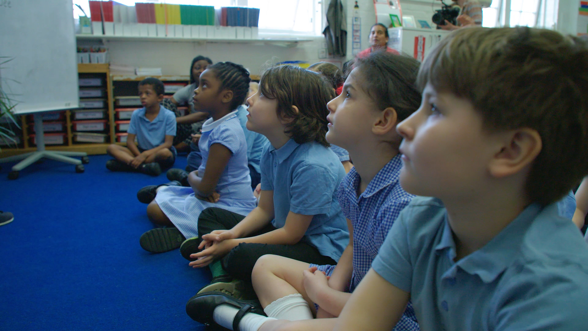 Primary school pupils sitting on the floor