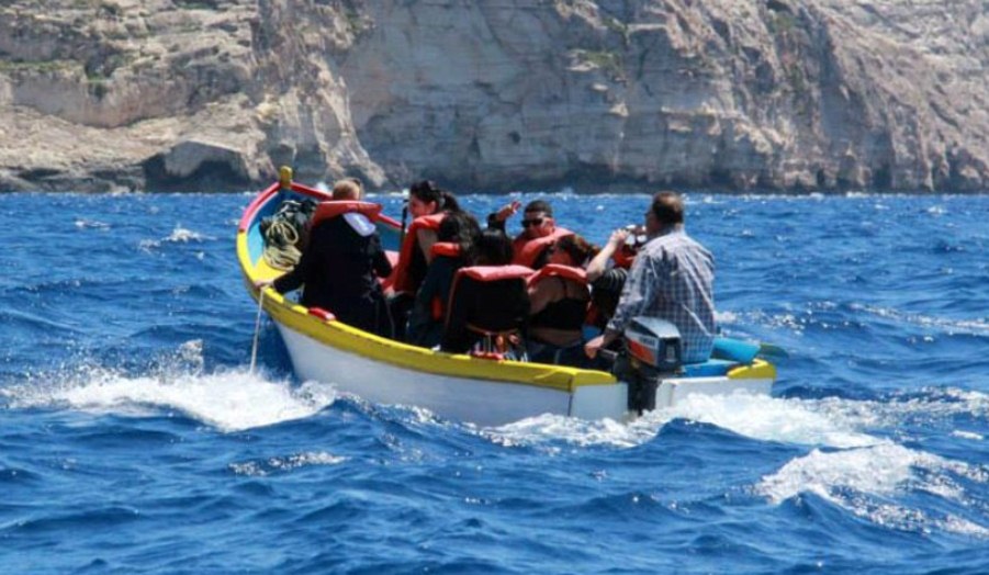 BA Travel and Tourism Management students in a boat, clear blue ocean. Colorful photo
