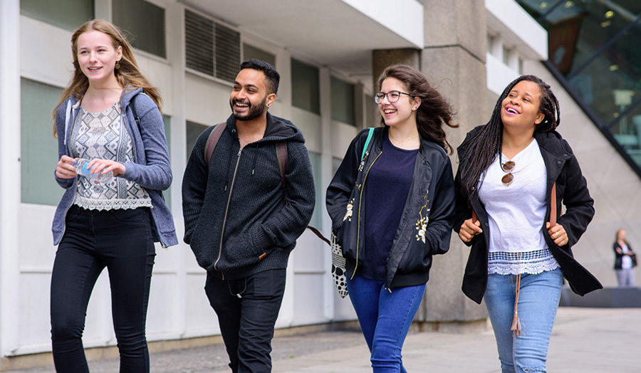 Photograph of four London Met students smiling and talking