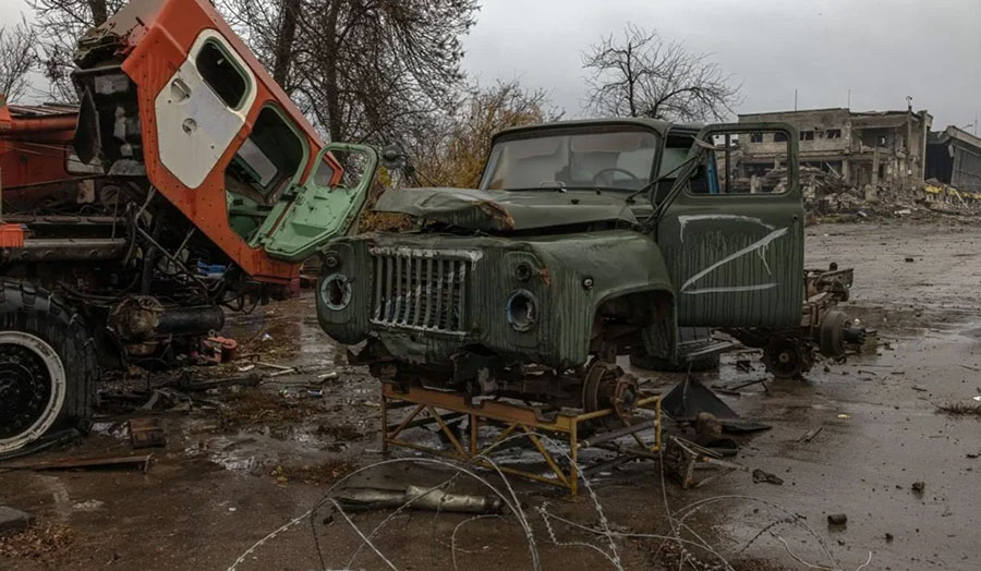 A wrecked military jeep in a junkyard