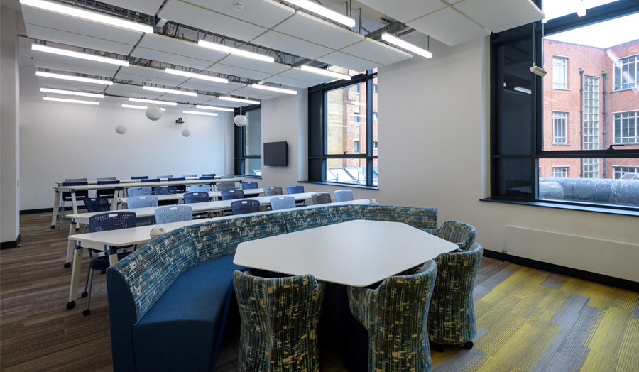 Roding Building first floor seminar room with rows of tables and huddle seating 