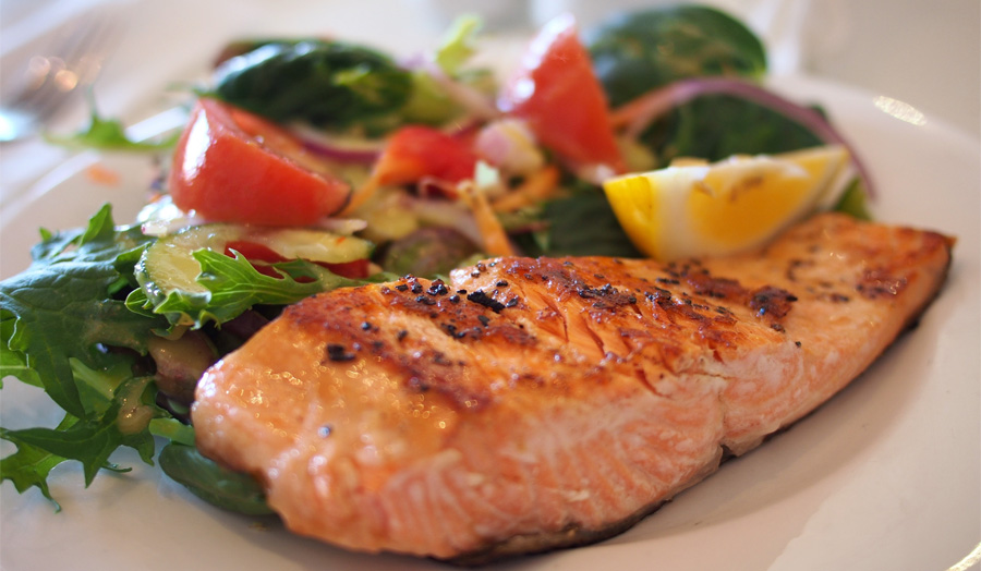 Plate with salmon fillet and salad leaves