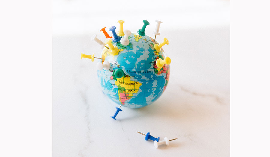 Globe pinned with colourful pins