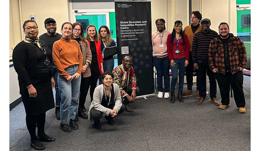A group of PhD students standing in front of the Centre's banner
