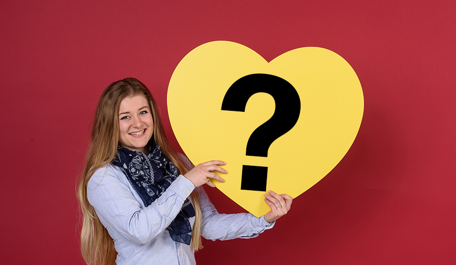 Student holding heart question mark