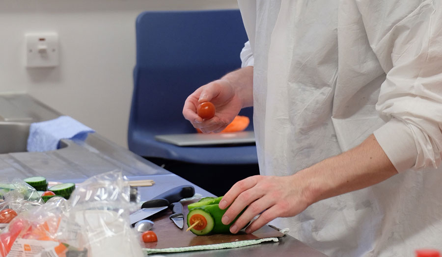 A student preparing a healthy vegetable dish with an interesting design