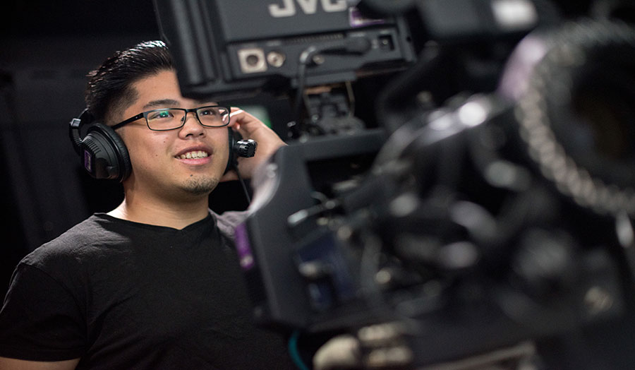 A student looking into the monitor of filming equipment