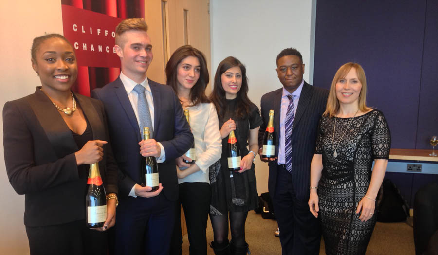 Students receiving bottles of champagne