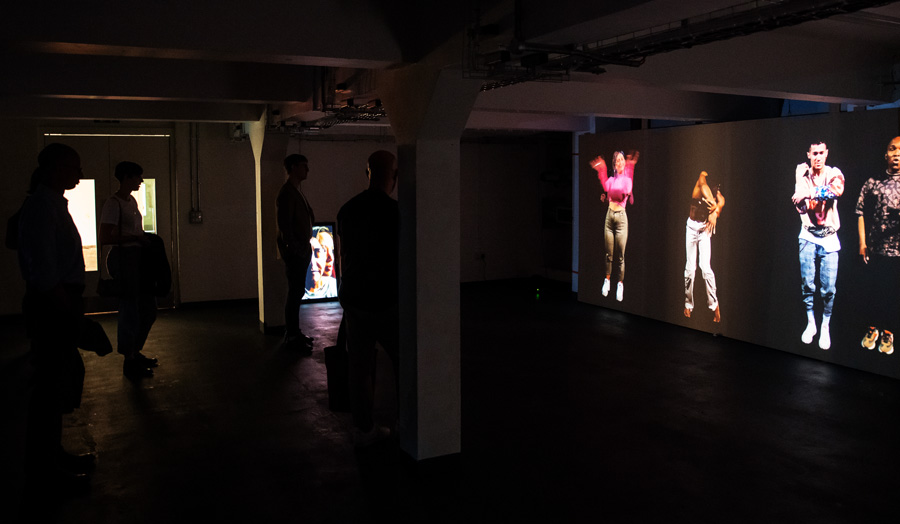 Installation featuring individuals on a large screen at The Cass Summer Show