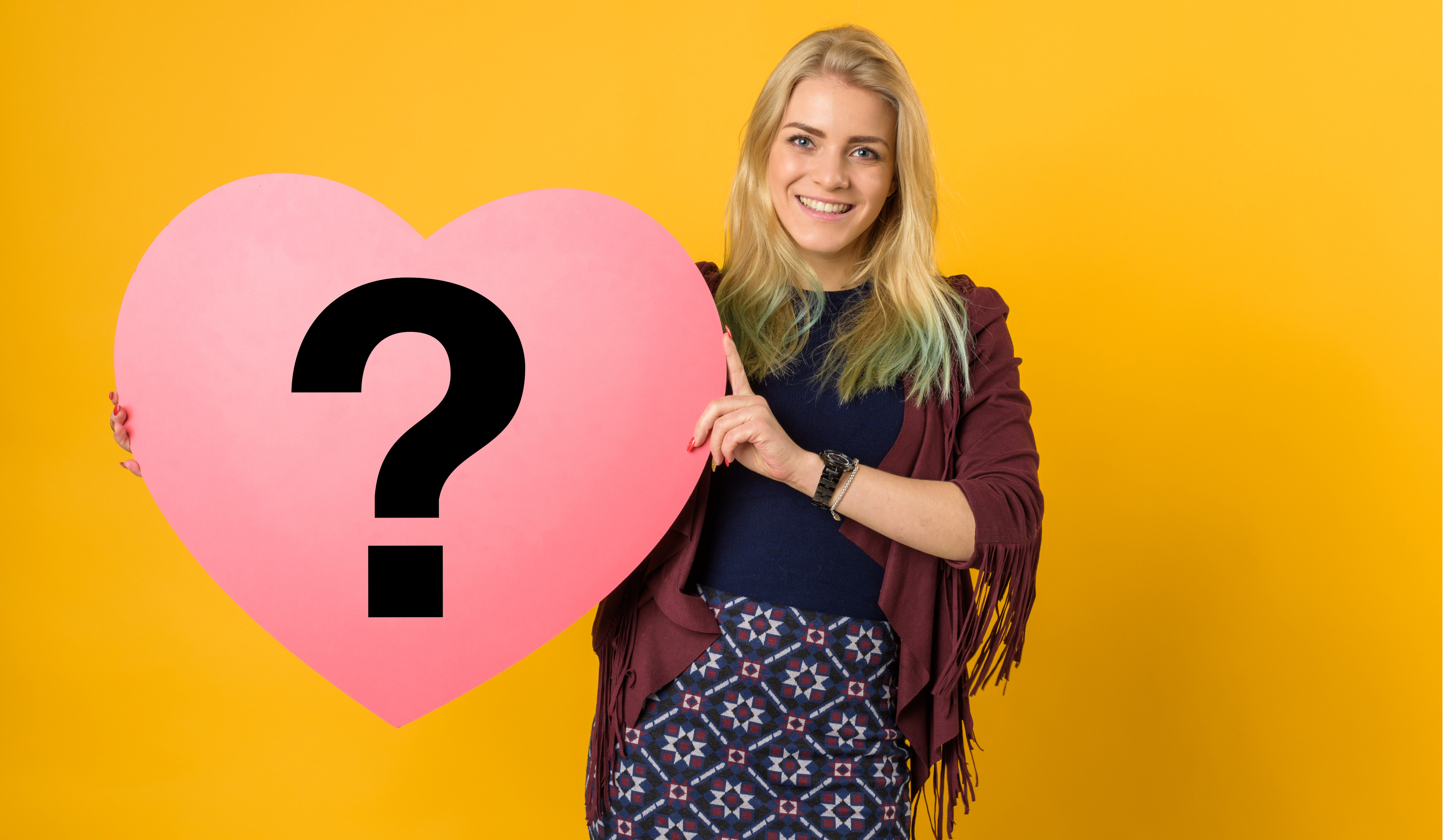 Student holding a heart with a question mark on it