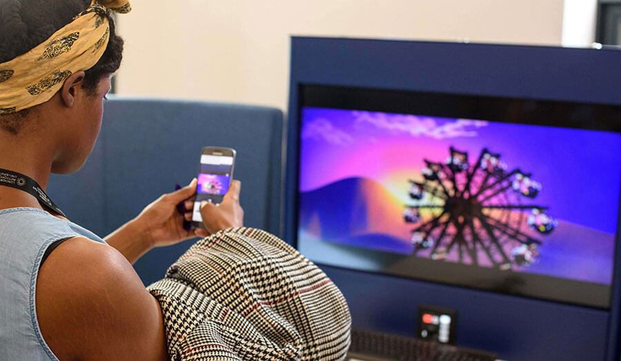 A girl engaging in a digitally interactive video using her phone