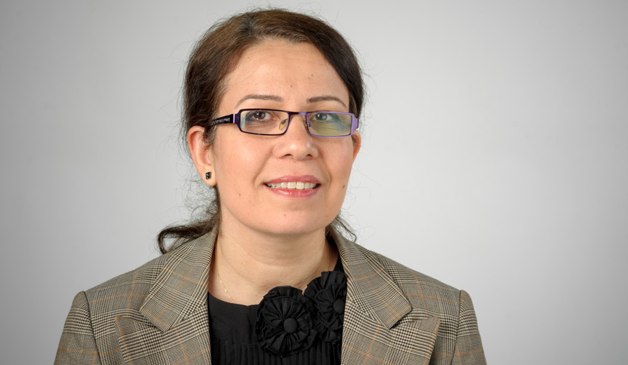 Female senior lecturer Dr Samireh Jorfi wearing spectacles poses against a grey background.