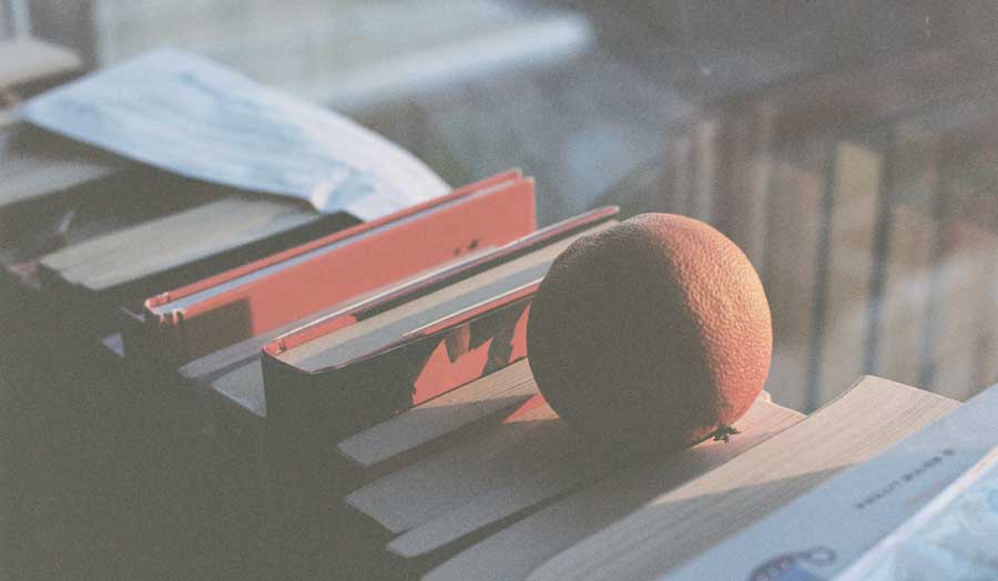 an orange on books