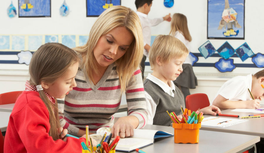 Primary school children learning with a teacher in a classroom