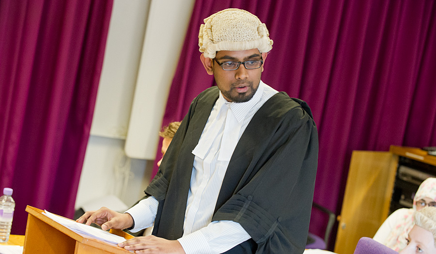 Male student in courtroom as lawyer