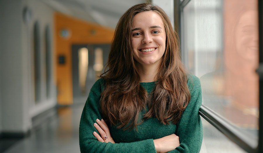 isobel facing the camera against a corridor background