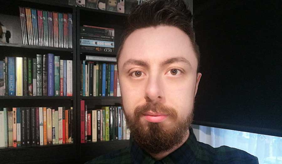 Student Daniel Redford standing in front of a bookcase