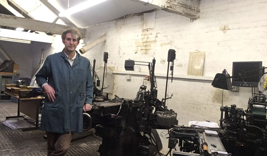Robert Hetherington, a male letterpress technician, stands in his workshop.