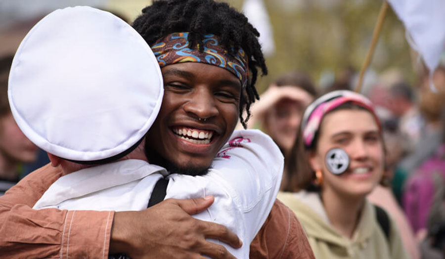 A climate change activist greeting a friend and hugging