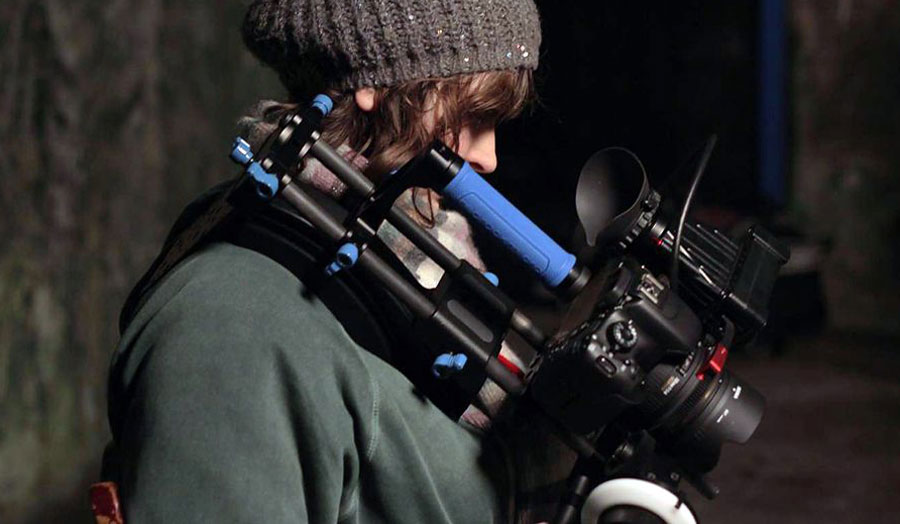 A person holding a shoulder-mounted camera