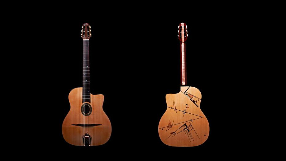 Two guitars sitting against a black background