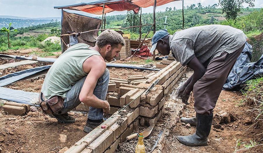 Edward Dale-Harris on site laying blocks with Fabienz Uwiragiye