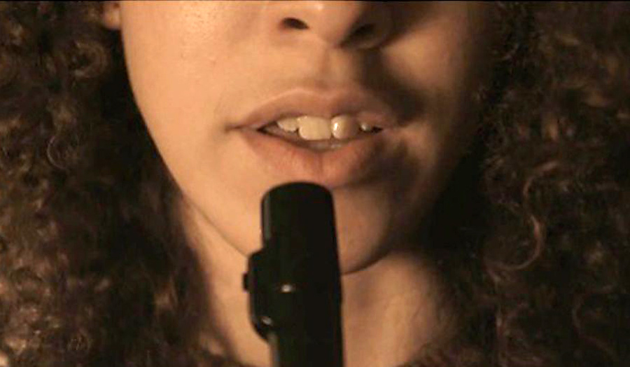 Close up of the female protagonist who is talking to a microphone