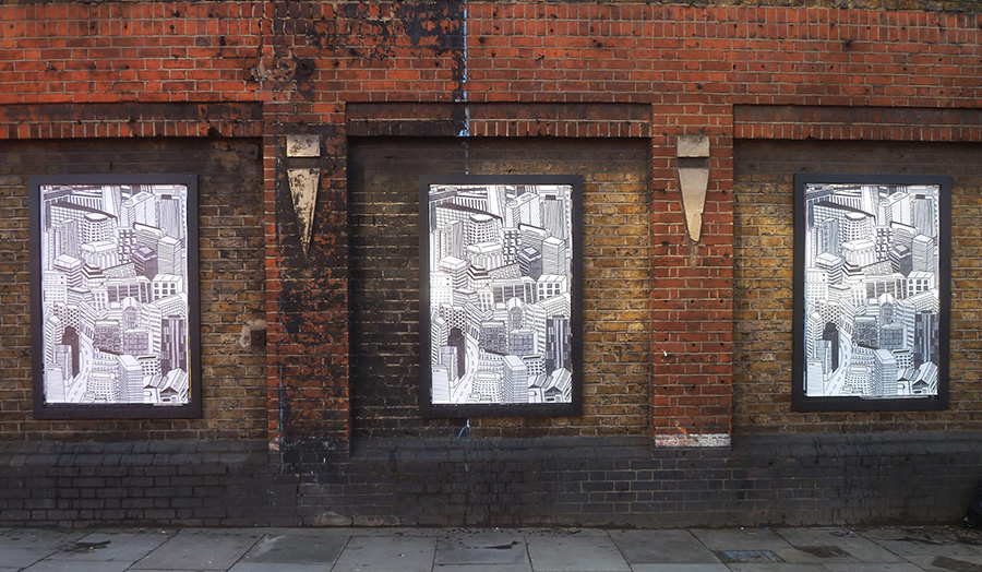 Two posters of line drawn sky scrapers pasted onto on a brick wall