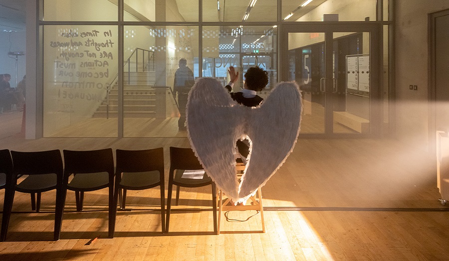 angel viewed from behind on waiting room seats in gallery