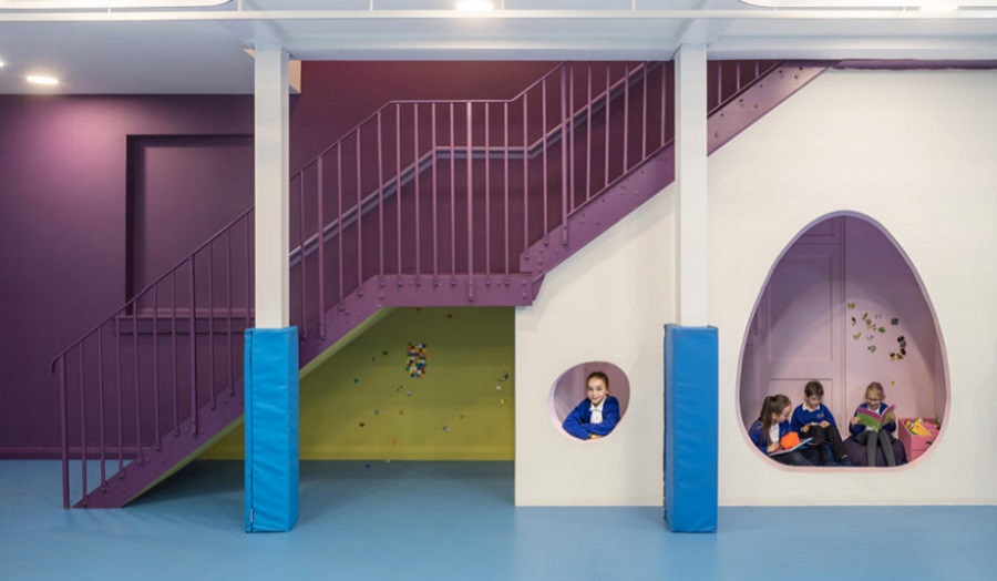 children play in spaces under a staircase